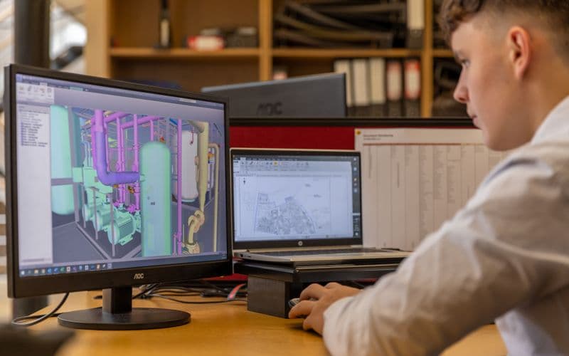 Projetista revisando o modelo 3D em dois monitores