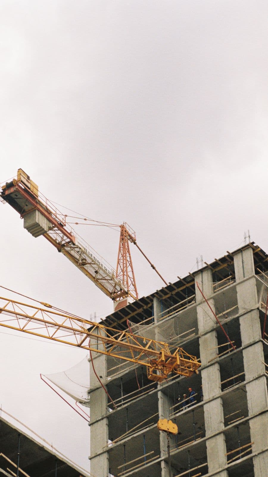 Guindastes sobre a estrutura de concreto de um edifício em obras